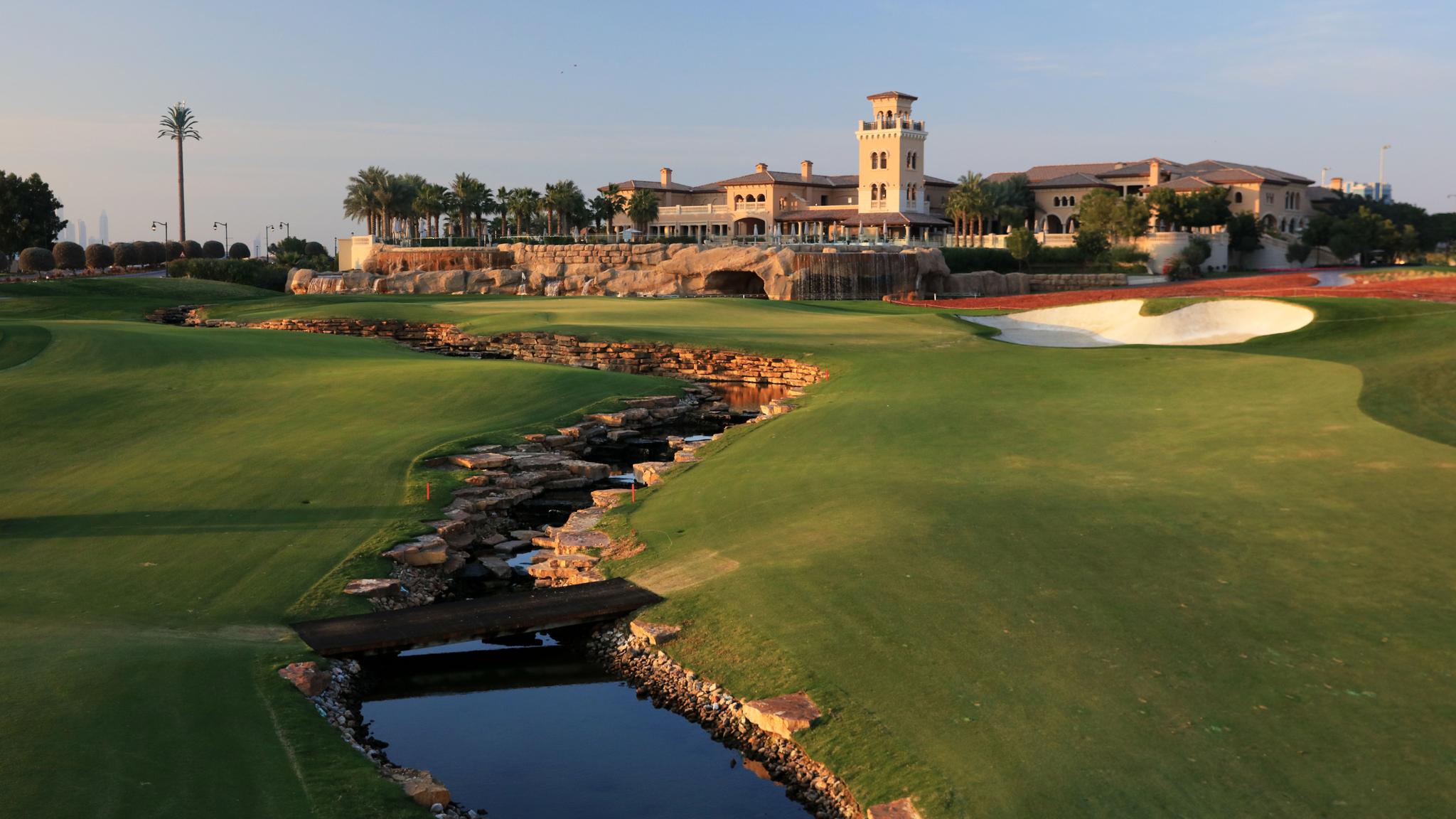 A well maintained fairway with a water hazard leading towards the clubhouse in Dubai