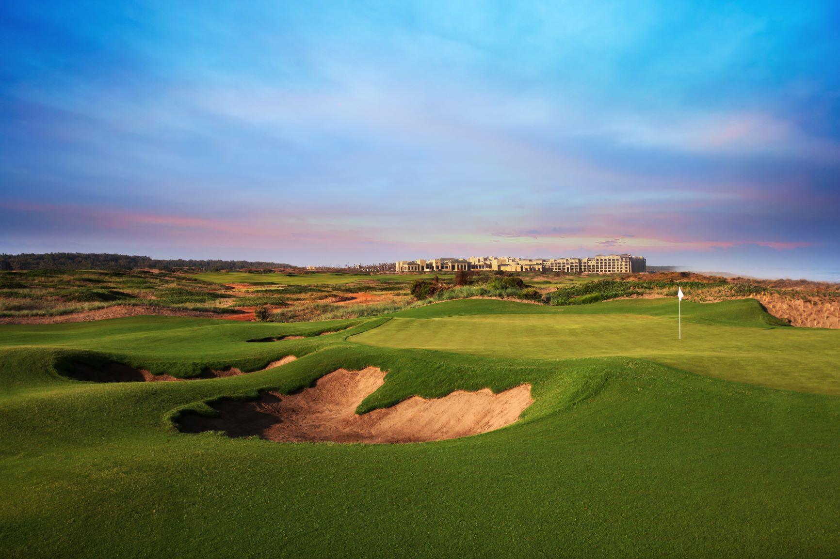 A smooth elevated green next to a sand bunker