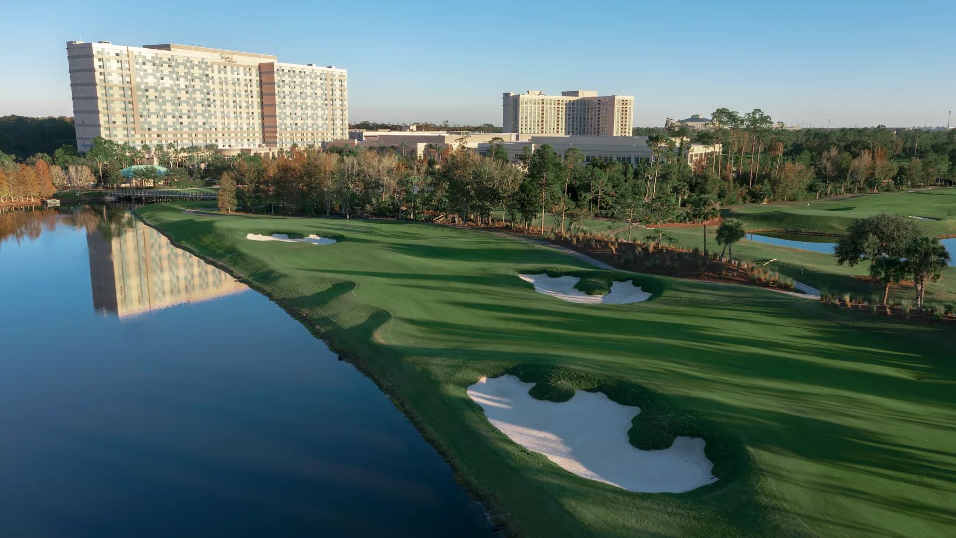 A well maintained fairway running besides a water hazard