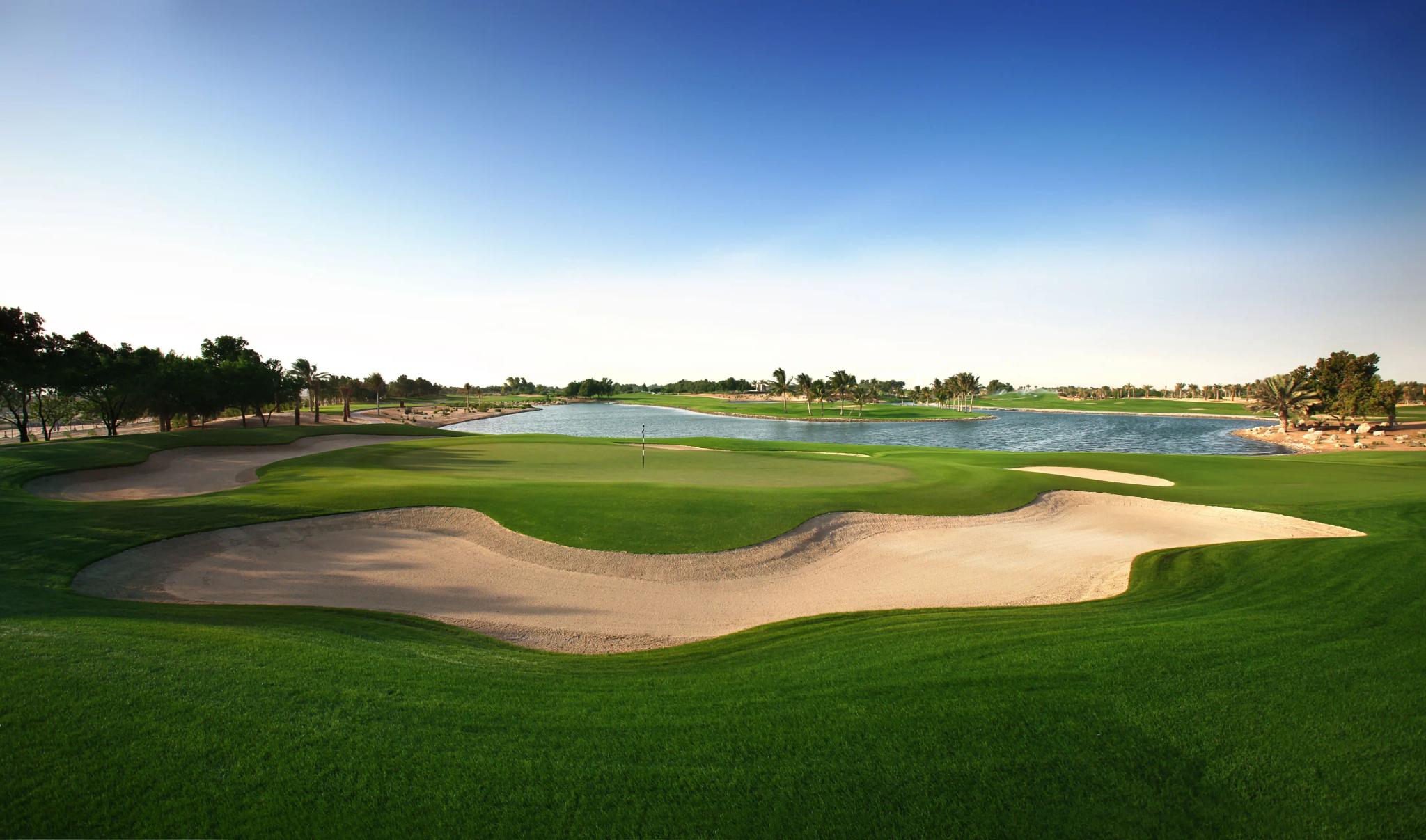 A large sand bunker on a well maintained fairway