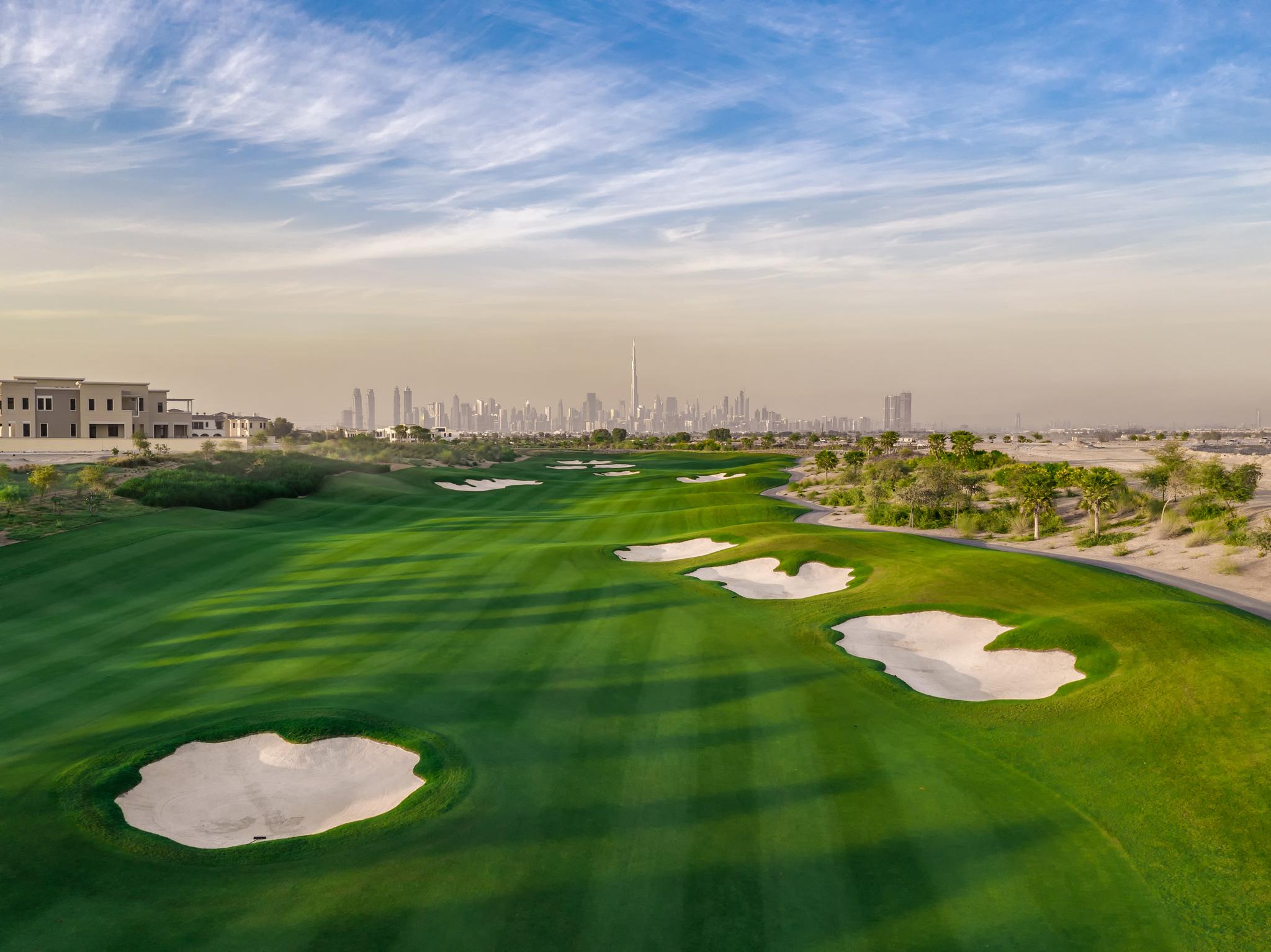 A well maintained fairway littered with sand bunkers