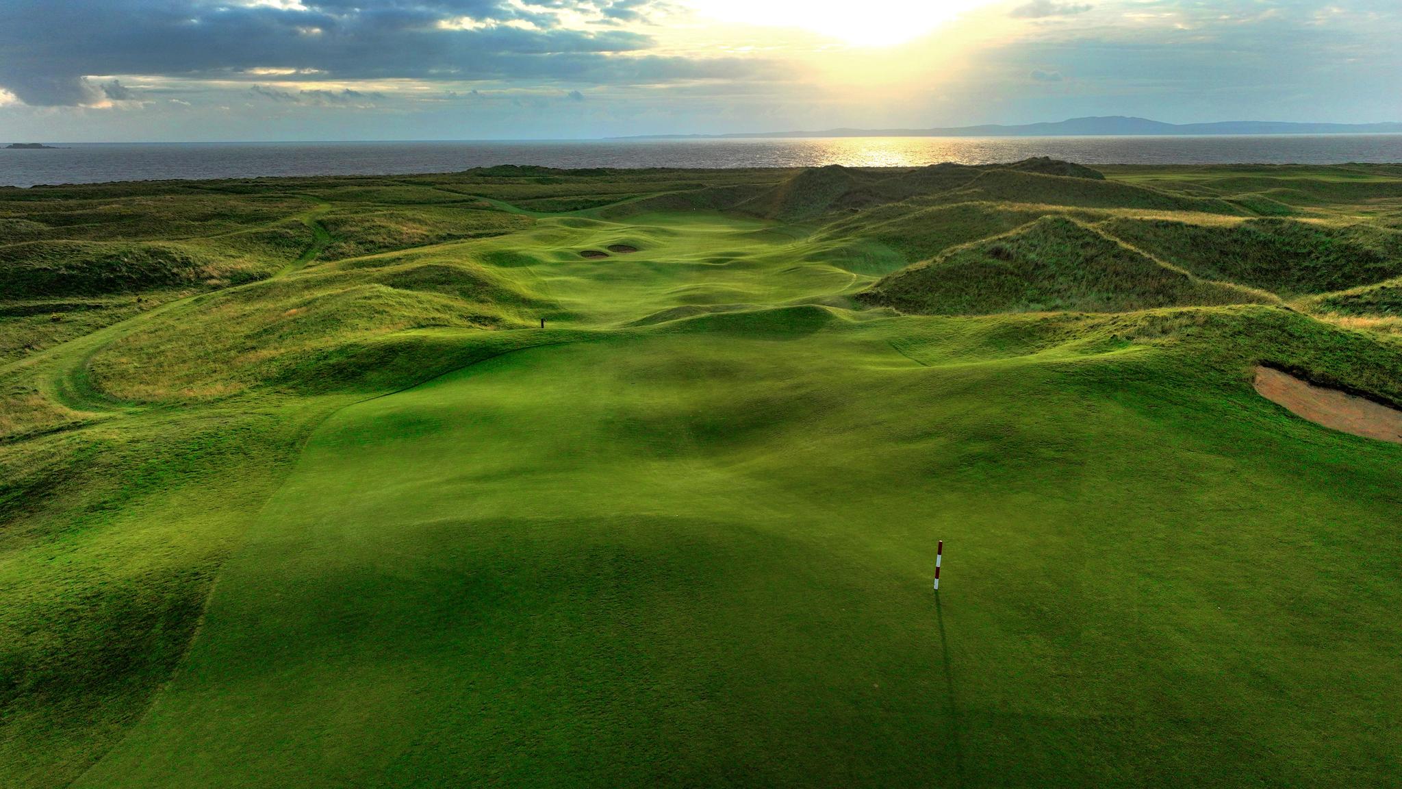 A well maintained fairway with rolling dunes leading to a smooth green