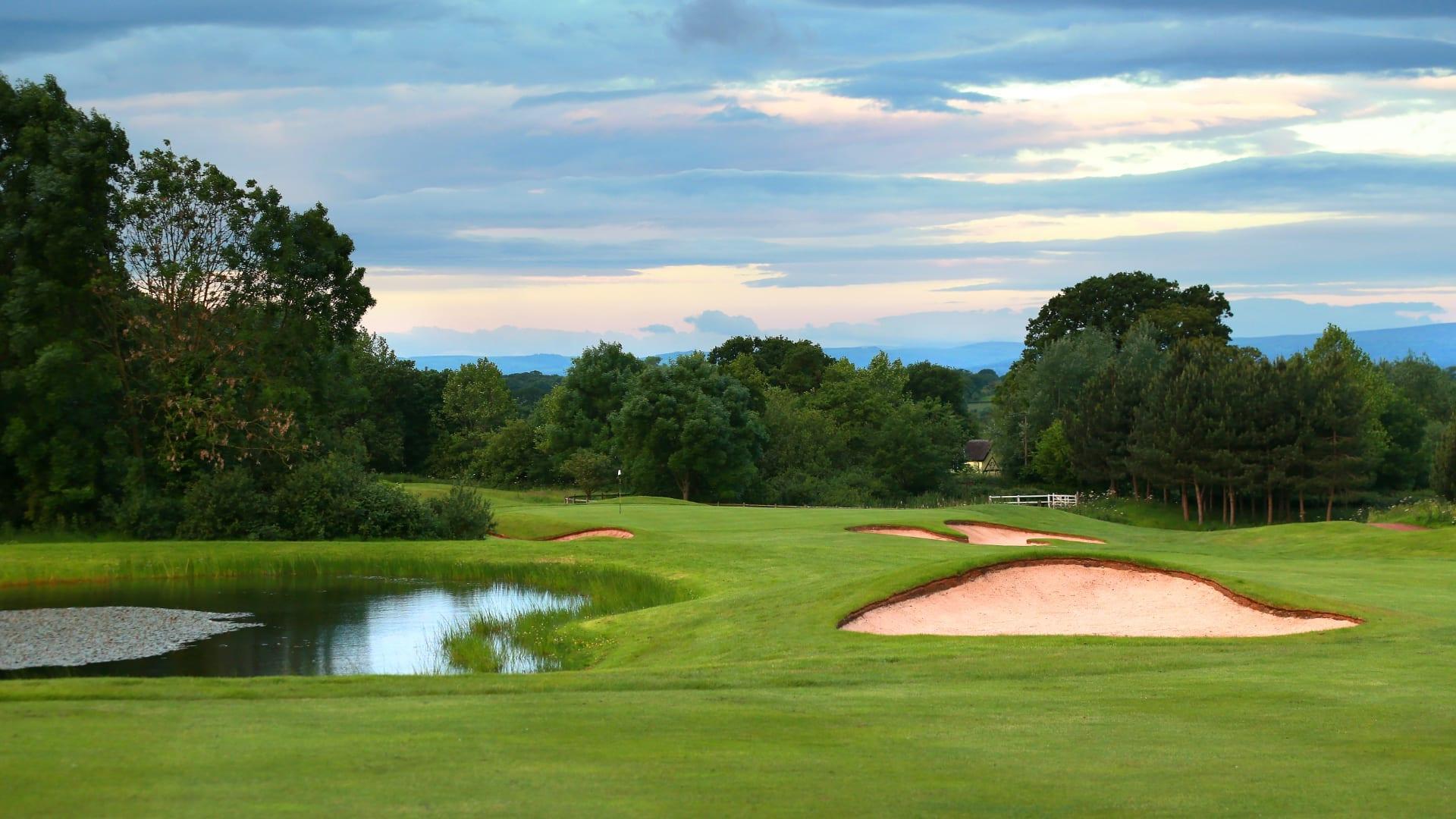View of an approach shot into the green, over bunkers and water