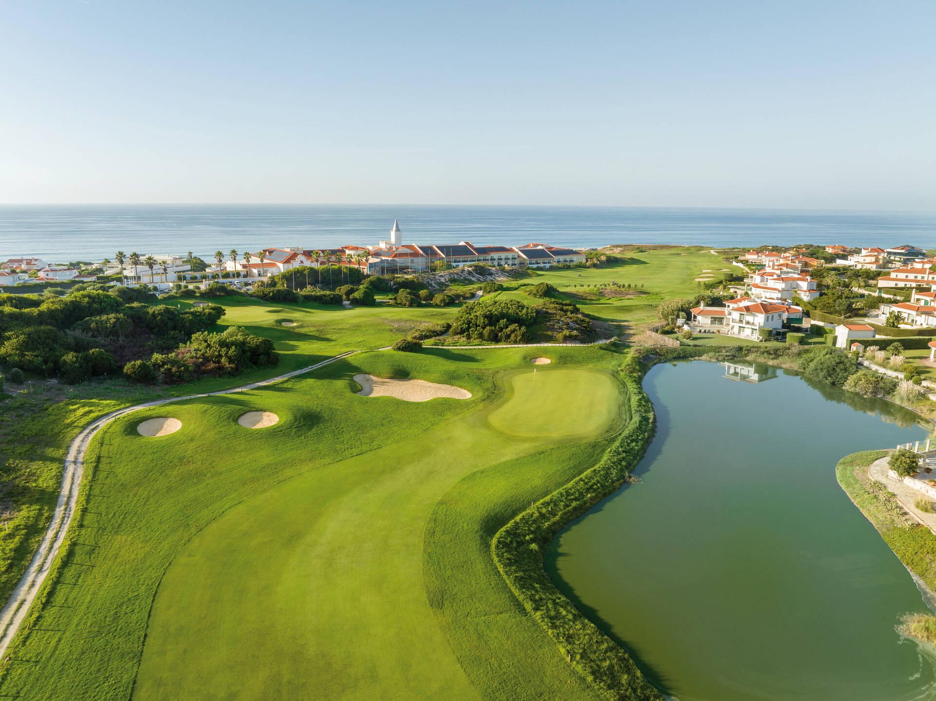 Overhead view of a well maintained fairway leading to a smooth green with sand bunkers