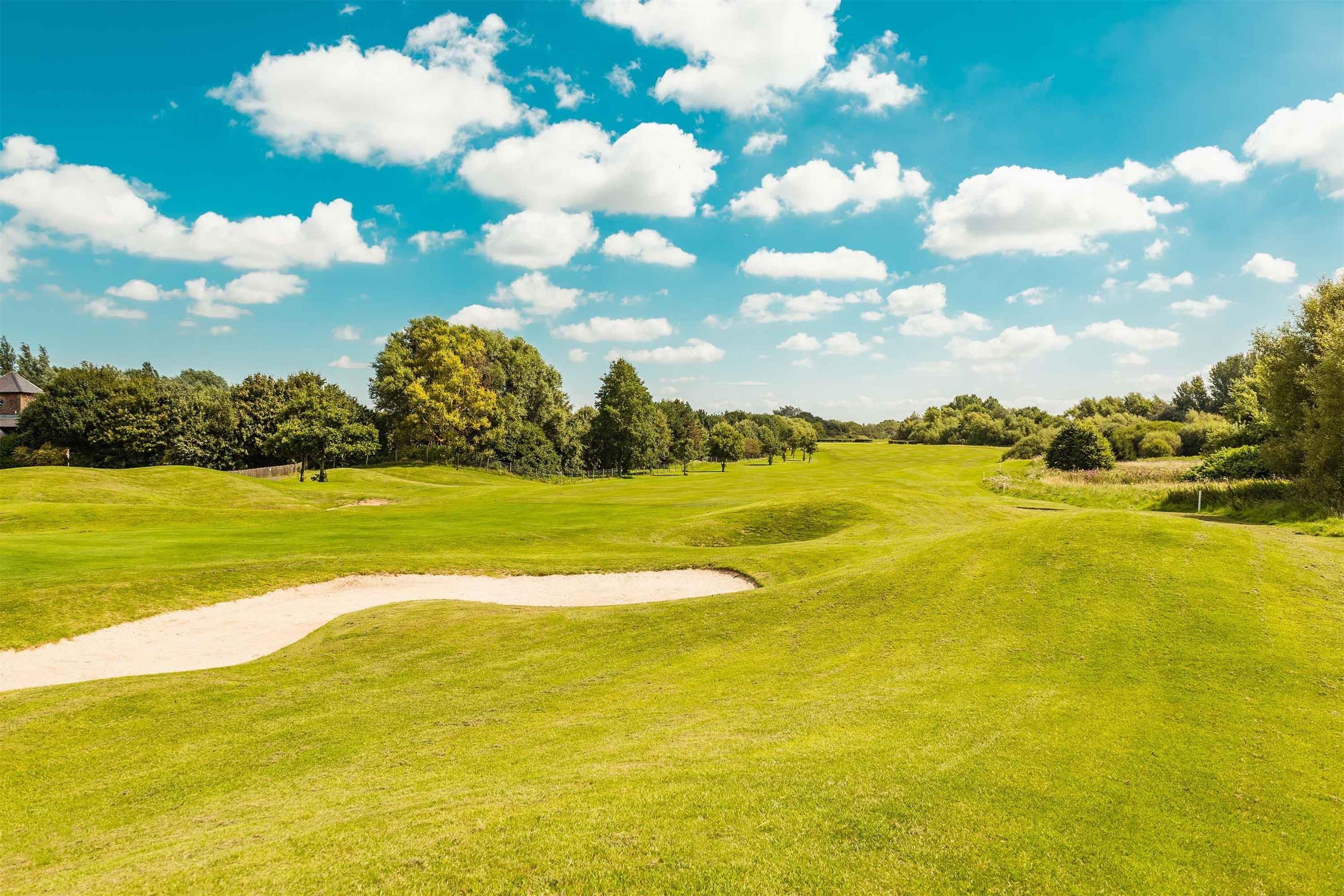 A well maintained fairway with a sand bunker