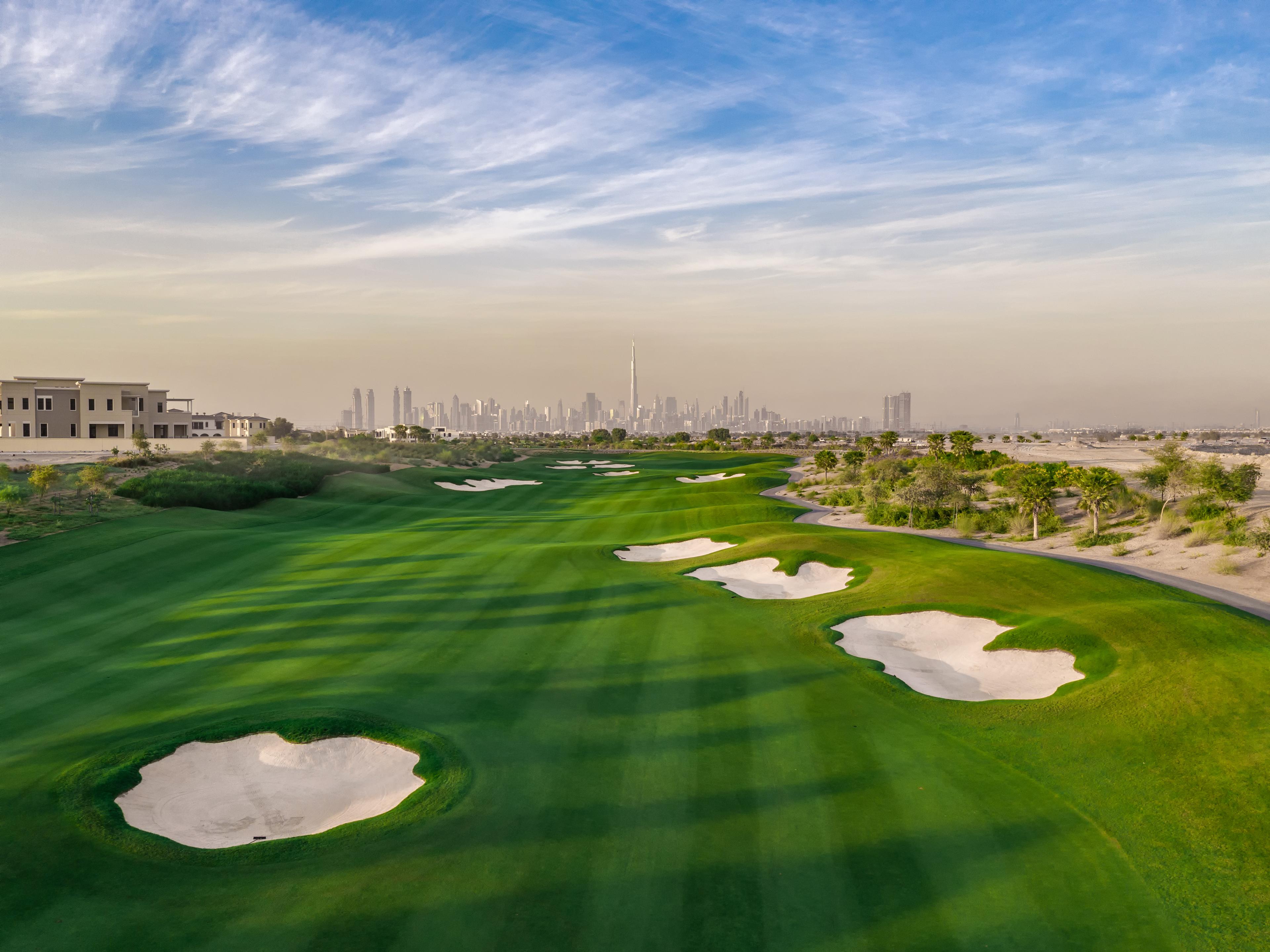A well maintained fairway littered with sand bunkers