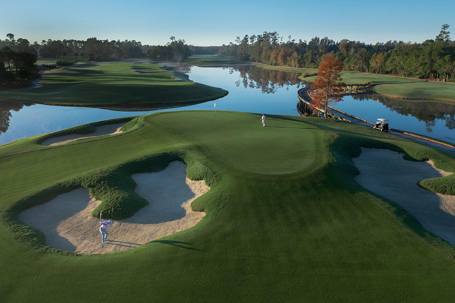 A smooth green sandwiched between a large sand bunker and a water hazard